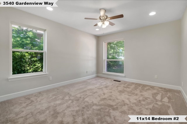 spare room featuring ceiling fan, a healthy amount of sunlight, and carpet floors