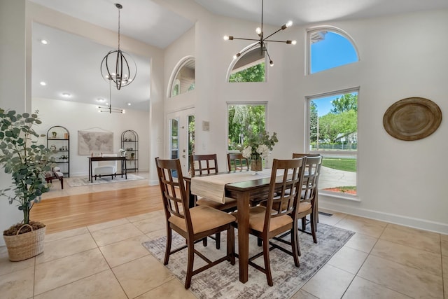 dining room featuring a high ceiling, an inviting chandelier, and light hardwood / wood-style floors