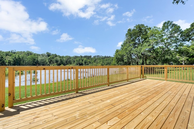 wooden terrace with a water view and a yard