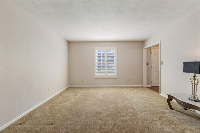 unfurnished living room with baseboards and carpet flooring