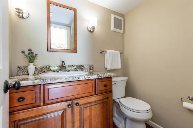bathroom featuring vanity, toilet, and visible vents