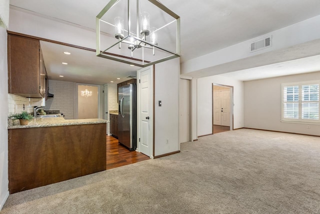 kitchen with stainless steel refrigerator with ice dispenser, visible vents, carpet floors, open floor plan, and an inviting chandelier