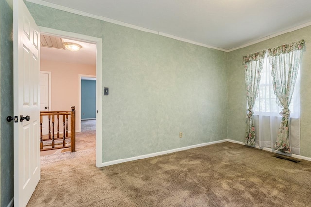 empty room featuring carpet floors, crown molding, visible vents, and baseboards