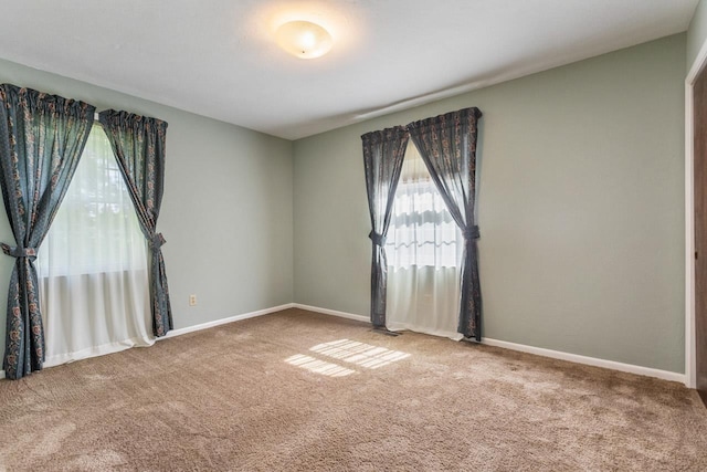 spare room with baseboards and carpet flooring