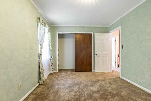 unfurnished bedroom featuring carpet floors, baseboards, ornamental molding, and a closet