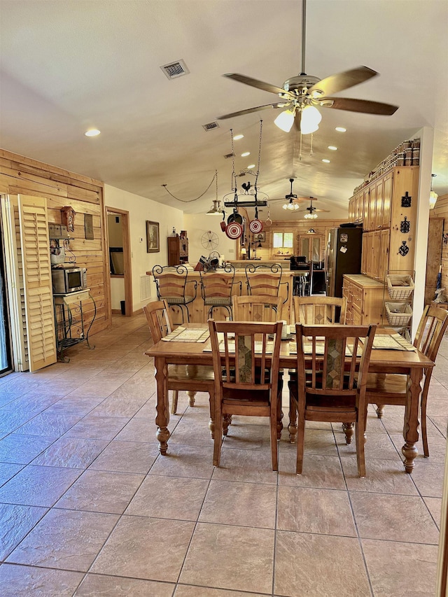 dining area with recessed lighting, vaulted ceiling, visible vents, a ceiling fan, and wooden walls