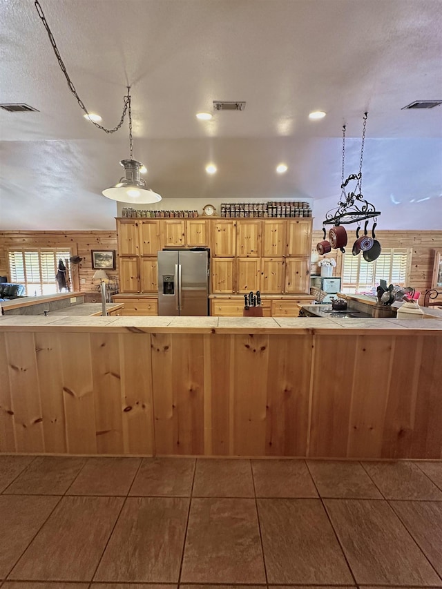 kitchen featuring visible vents, pendant lighting, stainless steel fridge with ice dispenser, and plenty of natural light