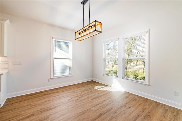 unfurnished dining area with light wood-type flooring and plenty of natural light