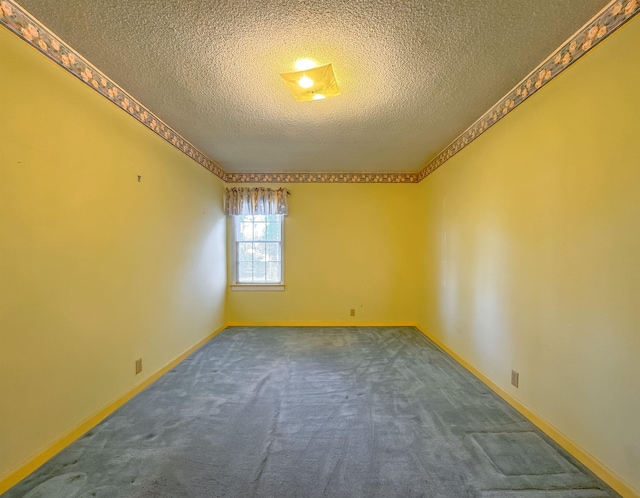 carpeted empty room featuring a textured ceiling