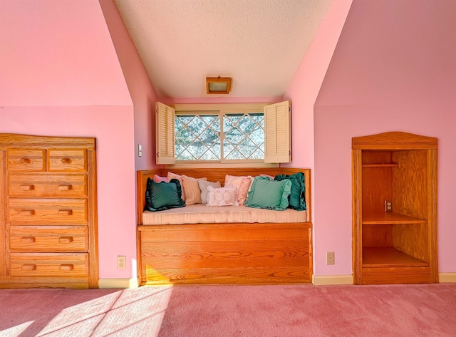 unfurnished bedroom with a textured ceiling, carpet floors, and lofted ceiling