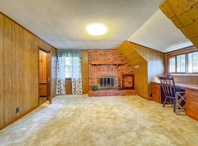 living room featuring a textured ceiling, light colored carpet, a brick fireplace, and wood walls