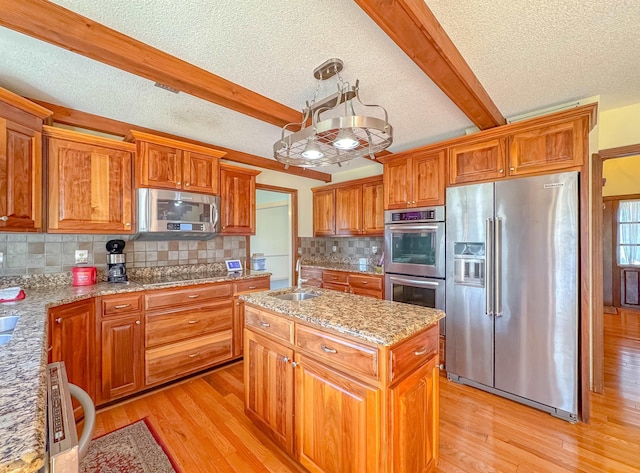 kitchen with decorative backsplash, stainless steel appliances, sink, beamed ceiling, and a center island