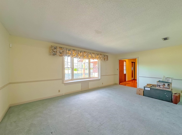 carpeted empty room with a textured ceiling