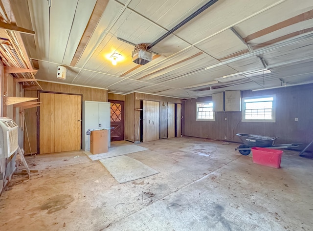 garage with wood walls and a garage door opener