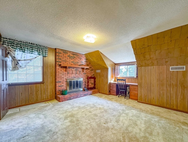 interior space featuring wood walls, light carpet, vaulted ceiling, and a brick fireplace