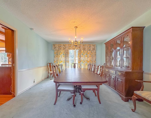 dining room with light colored carpet, an inviting chandelier, and plenty of natural light