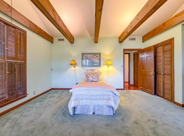 carpeted bedroom with beam ceiling and a closet