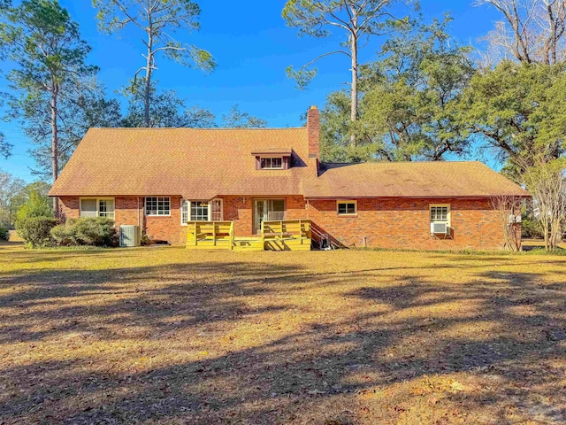 view of front of property featuring a front yard and central AC