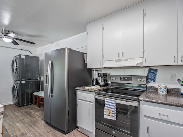 kitchen with white cabinets, stacked washer / drying machine, light hardwood / wood-style floors, and appliances with stainless steel finishes