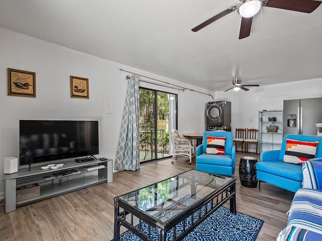 living room featuring wood-type flooring and stacked washer and clothes dryer