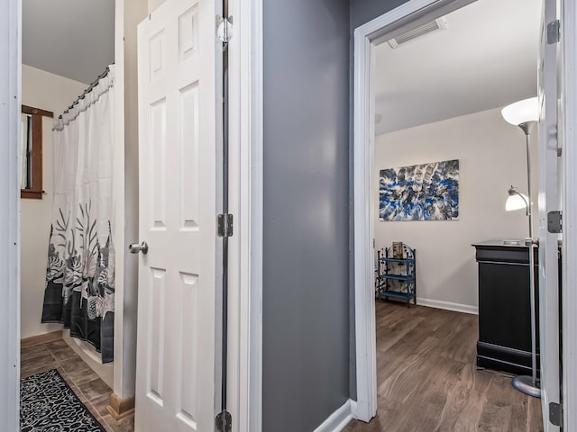 corridor with dark hardwood / wood-style flooring