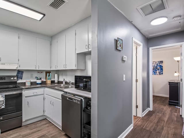 kitchen featuring dark wood-type flooring, black appliances, ventilation hood, sink, and white cabinetry