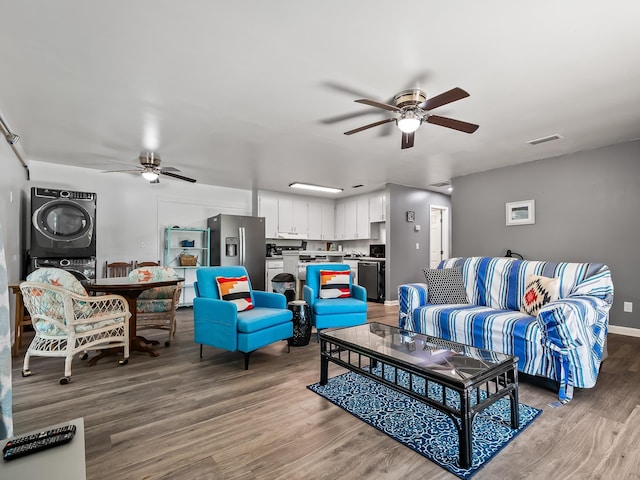 living room with stacked washer and dryer and light hardwood / wood-style floors