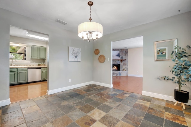 6427 Count Turf Trl, Tallahassee, FL 32309 - unfurnished dining area featuring stone tile floors, a stone fireplace, and baseboards
