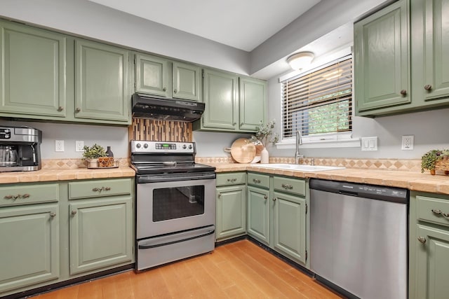 6427 Count Turf Trl, Tallahassee, FL 32309 - kitchen featuring stainless steel appliances, under cabinet range hood, a sink, green cabinetry, and light countertops