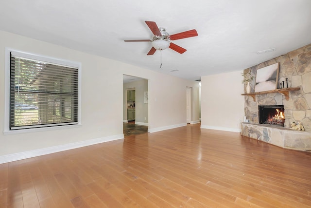 6427 Count Turf Trl, Tallahassee, FL 32309 - unfurnished living room with a fireplace, a ceiling fan, baseboards, and wood finished floors