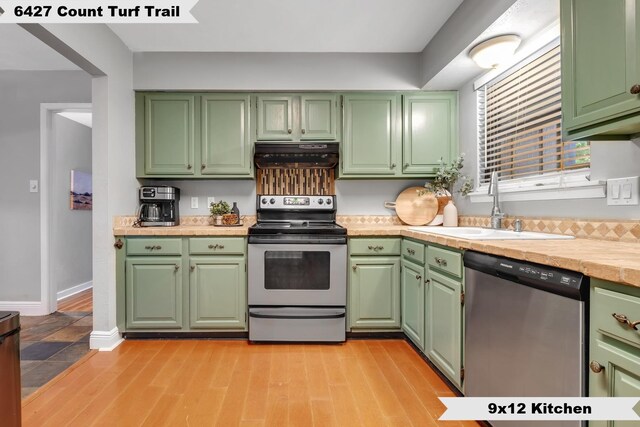 6427 Count Turf Trl, Tallahassee, FL 32309 - kitchen with appliances with stainless steel finishes, under cabinet range hood, a sink, light countertops, and green cabinetry
