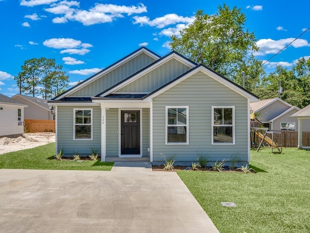 bungalow-style house featuring board and batten siding, a front yard, and fence