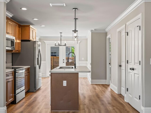 100 Kiowa Trl, Crawfordville, FL 32327 - kitchen with stainless steel appliances, a sink, light countertops, ornamental molding, and decorative light fixtures