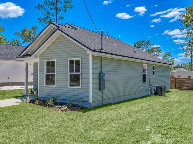 back of house featuring central AC, a yard, fence, and roof with shingles