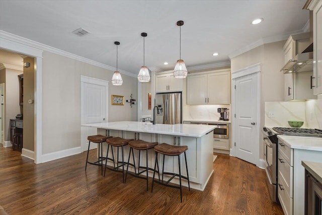 2642 Opequon Bnd, Tallahassee, FL 32312 - kitchen featuring appliances with stainless steel finishes, a kitchen breakfast bar, dark wood finished floors, crown molding, and a center island with sink