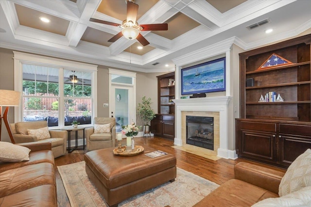 2642 Opequon Bnd, Tallahassee, FL 32312 - living area with ceiling fan, a tiled fireplace, ornamental molding, beamed ceiling, and wood finished floors