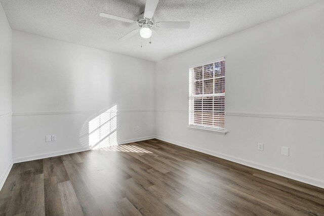 unfurnished room with ceiling fan, dark wood-type flooring, and a textured ceiling