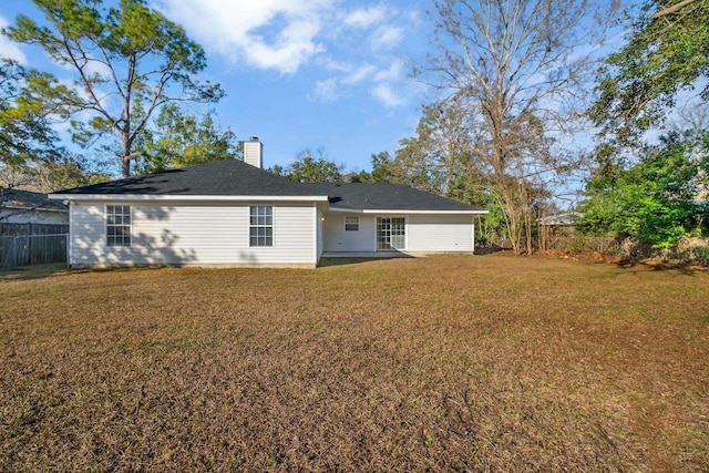 rear view of property with a yard