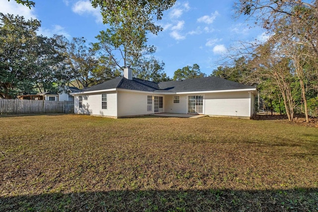 rear view of house featuring a yard and a patio