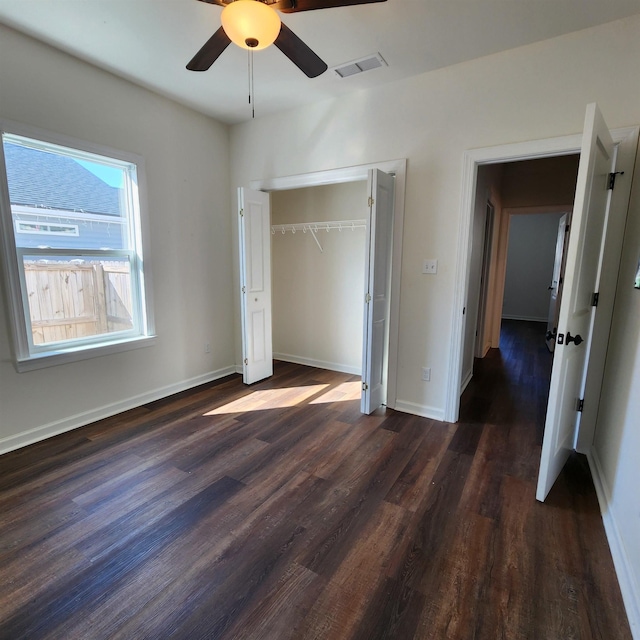 unfurnished bedroom featuring ceiling fan, a closet, and dark hardwood / wood-style floors