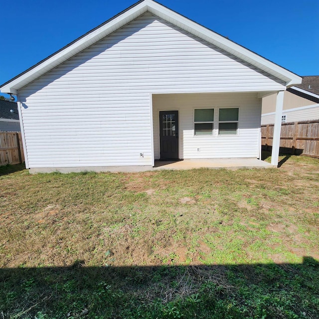 rear view of house with a yard and a patio