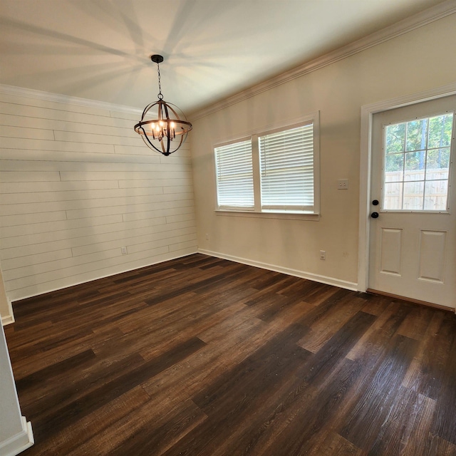 unfurnished dining area with a chandelier, dark hardwood / wood-style floors, and ornamental molding