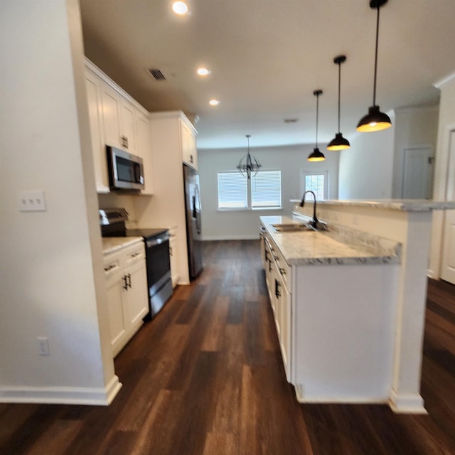 kitchen featuring white cabinets, sink, stainless steel appliances, and an island with sink