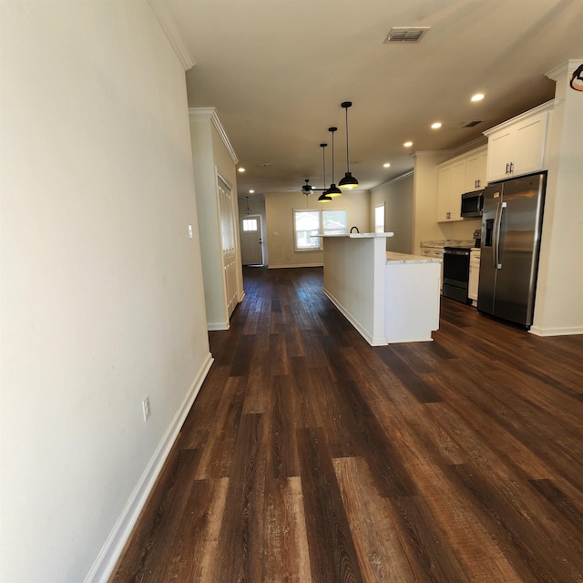 kitchen featuring a center island, hanging light fixtures, stainless steel appliances, dark wood-type flooring, and white cabinets