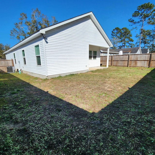 view of side of home with a lawn and central air condition unit