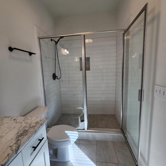 bathroom featuring tile patterned flooring, vanity, toilet, and walk in shower