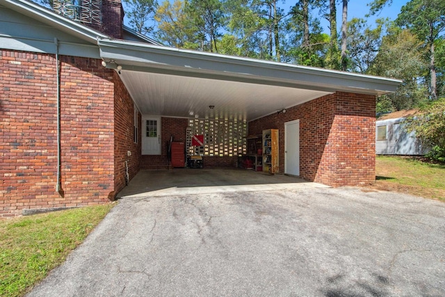view of car parking with an attached carport and aphalt driveway