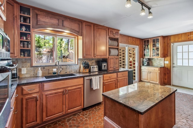 kitchen with decorative backsplash, dishwasher, dark stone counters, a sink, and open shelves