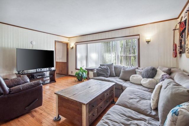 living room with ornamental molding and light wood-style flooring