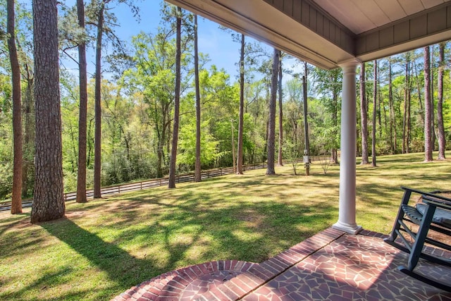 view of yard featuring fence and a forest view